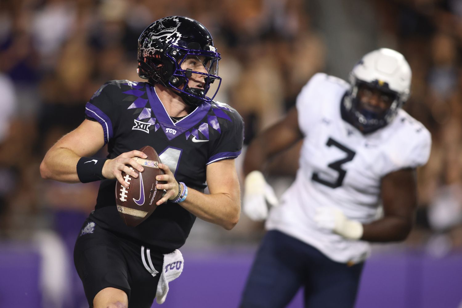 Sep 30, 2023; Fort Worth, Texas, USA; TCU Horned Frogs quarterback Chandler Morris (4) rolls out to pass against West Virginia Mountaineers defensive lineman Tomiwa Durojaiye (3) in the second quarter at Amon G. Carter Stadium. Mandatory Credit: Tim Heitman-USA TODAY Sports